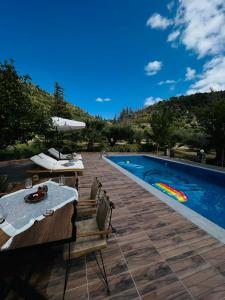 un patio con mesa y sillas junto a una piscina en Villa Domenico en Vryses