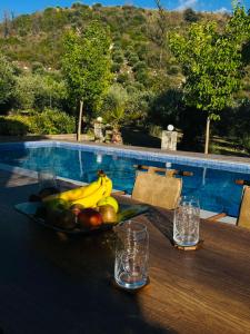 uma taça de fruta numa mesa ao lado de uma piscina em Villa Domenico em Vryses