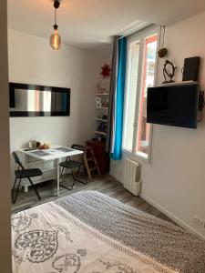 聖旺的住宿－Cosy nest from 10 minutes PARIS centre，客厅配有书桌和窗户。