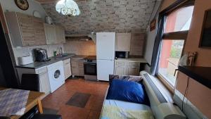 a small kitchen with a white refrigerator and a table at Sárkány Lak in Diósd