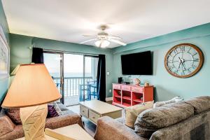 a living room with a couch and a clock on the wall at x Sea Marsh II 503 in Myrtle Beach