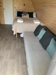 un paio di letti in una camera con pavimenti in legno di The Burrow - Sleeps 4 a Burnfoot