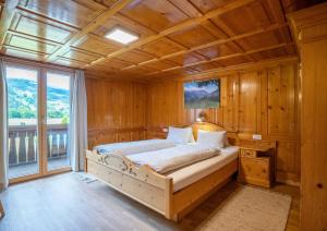 una camera con un letto in una stanza con pareti in legno di Ferienhaus Fratte a Schruns
