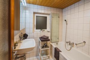 a bathroom with a sink and a shower and a tub at Ferienhaus Fratte in Schruns