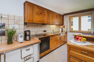 a kitchen with wooden cabinets and a bowl of fruit on the counter at Ferienhaus Fratte in Schruns