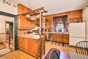 a kitchen with wooden cabinets and a white refrigerator at Beautiful Historic House In Amish Country in Ephrata
