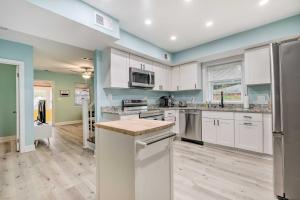 una cucina con mobili bianchi e un piano di lavoro di Updated North Beach Cottage Pet Friendly! a Deale