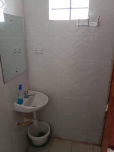 Baño blanco con lavabo y aseo en Serene Studio Near JKIA/SGR, en Nairobi