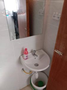a bathroom with a sink and a toilet and a mirror at Serene Studio Near JKIA/SGR in Nairobi +9 photos