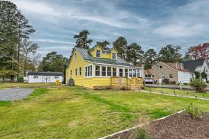 una casa amarilla con techo verde en un patio en Updated North Beach Cottage Pet Friendly!, en Deale