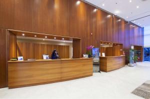 a woman sitting at a counter in a lobby at NH Torino Lingotto Congress in Turin