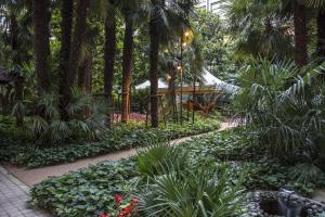 un giardino con piante e palme e un vialetto di NH Torino Lingotto Congress a Torino