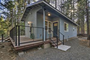 的住宿－Secluded Butte Meadows Cabin with Deck and Grill!，树林里有一个大门廊的小房子