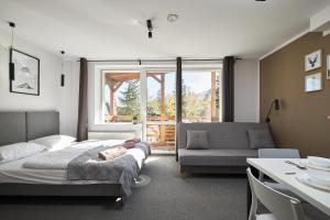 sypialnia z łóżkiem, kanapą i stołem w obiekcie Villa Alpina w Szklarskiej Porębie