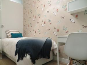 a bedroom with a bed with butterflies on the wall at Apartamento Roma in Lisbon