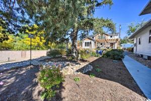 a house with a yard with flowers and a driveway at Adorable Castle Rock Cottage Walk to Town! in Castle Rock