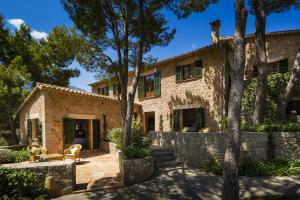 una vista exterior de una casa de piedra con árboles en Astounding Mallorca Villa La Mejor Vista 5 Bedrooms All Inclusive & Private Heated Pool Banyalbufar, en Banyalbufar