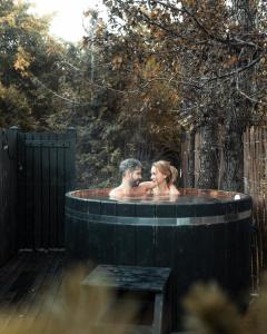 a man and a woman in a hot tub at INNI - Boutique apartments in Hveragerði