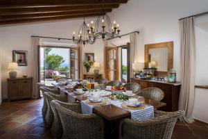 un comedor con una mesa larga y sillas en Astounding Mallorca Villa La Mejor Vista 5 Bedrooms All Inclusive & Private Heated Pool Banyalbufar, en Banyalbufar