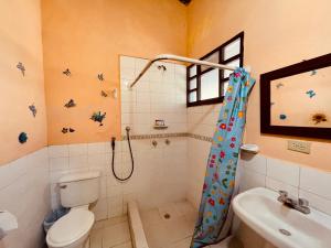 een badkamer met een douche, een toilet en een wastafel bij Hostería EL Trapiche Lodge & Spa in Baños