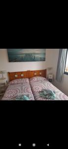 a bedroom with a bed with a painting on the wall at Dunes to explore and relax right by the desert wifi in Corralejo