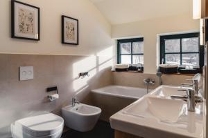 a bathroom with two sinks and a toilet and a tub at Altsächsischer Gasthof Kleines Vorwerk in Sayda