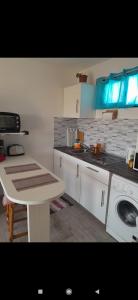 a kitchen with white cabinets and a table and a sink at Dunes to explore and relax right by the desert wifi in Corralejo