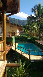 a swimming pool in front of a house at Brisa Maresias in Maresias