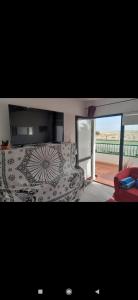 a living room with a couch and a television at Dunes to explore and relax right by the desert wifi in Corralejo