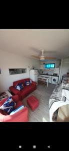 a living room with a red couch and a kitchen at Dunes to explore and relax right by the desert wifi in Corralejo