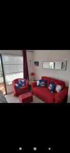 a living room with a red couch and two chairs at Dunes to explore and relax right by the desert wifi in Corralejo