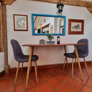 stół z 2 krzesłami i lustrem na ścianie w obiekcie Casita Artemisa - Tiny House Romántica y Mágica w mieście Villa de Leyva
