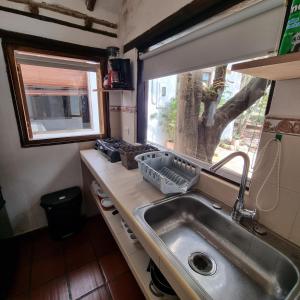 a kitchen with a sink and a tree in the window at Casita Artemisa - Tiny House Romántica y Mágica in Villa de Leyva