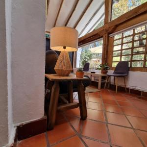 a room with a table with a lamp on it at Casita Artemisa - Tiny House Romántica y Mágica in Villa de Leyva