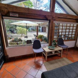 a room with two chairs and a table and an umbrella at Casita Artemisa - Tiny House Romántica y Mágica in Villa de Leyva