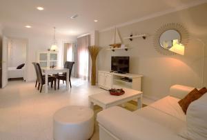 sala de estar con sofá blanco y mesa en Apartamentos Turísticos Los Patios, en Rota