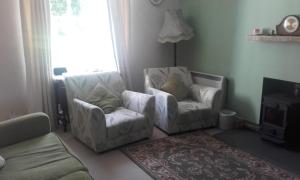 2 Stühle und ein Sofa im Wohnzimmer in der Unterkunft Braeside cottage in Tarskavaig