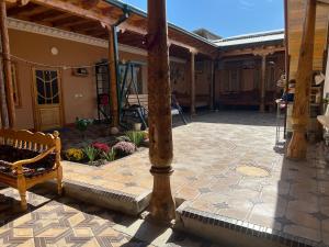 a patio with a pillar and a bench on a patio at MOHINUR Hostel in Bukhara