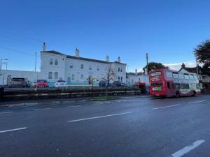 um autocarro vermelho de dois andares a descer uma rua em Modern Studio with Free Parking near sea-station-shops em Portslade