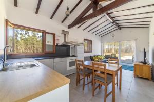 eine Küche und ein Esszimmer mit einem Tisch und Stühlen in der Unterkunft Quinta das Camarinhas in Cantanhede