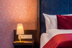 - une chambre avec un lit et une table avec une lampe dans l'établissement Logis Hotel QUARTIER 5, Sächsische Schweiz, mit Restaurant, Café & Bar, à Gohrisch