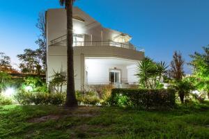 Casa blanca con balcón por la noche en Gelina Apartments, en Plataniás