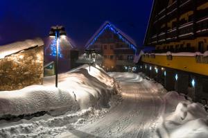 a snow covered street at night with a bridge at Borgo Stalle in Prato Nevoso
