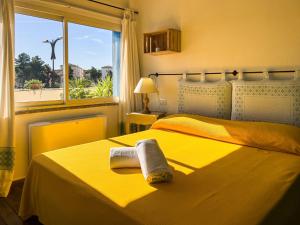 a yellow bedroom with two beds and a window at La Terrazza Guesthouse in Olbia