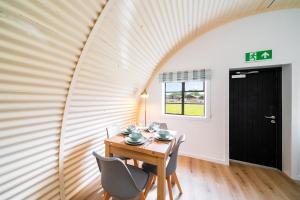 a dining room with a wooden table and chairs at Cultybraggan Hut 35 in Comrie