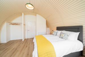 um quarto com uma cama grande num quarto em Cultybraggan Hut 35 em Comrie