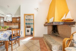 a kitchen and a dining room with a fireplace at Villa Maladroxia in Maladroscia
