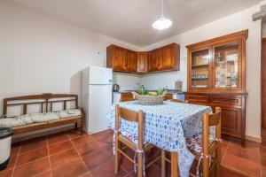 cocina con mesa y nevera blanca en Domus de Janas en SantʼAntìoco