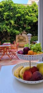 a table with a plate of fruit on a table at Hôtel de la Fontaine in Nice