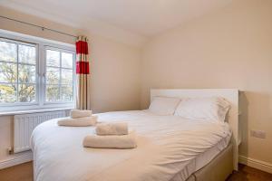 a bedroom with a large white bed with two towels on it at Cosy 2 Bedroom Home in Wigan in Wigan